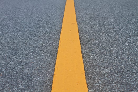 asphalt road with marking lines and tire tracks. Close up photo with selective focus