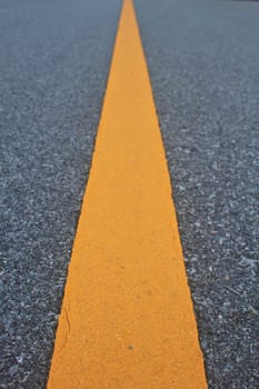 asphalt road with marking lines and tire tracks. Close up photo with selective focus