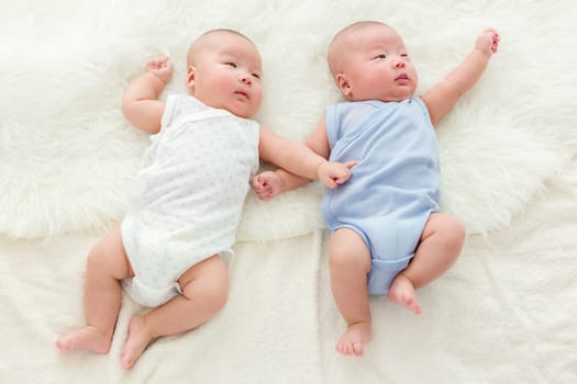 Twin babies laying on bed