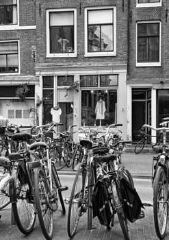 BW photo of weaned bicycle in front of houses in the center of Amsterdam.(Netherlands). All potential trademarks are removed.
