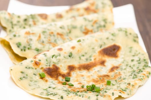 Close-up of fried egg cakes with green chids