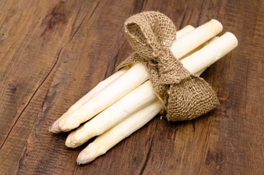 Bunch white asparagus with bow on a table