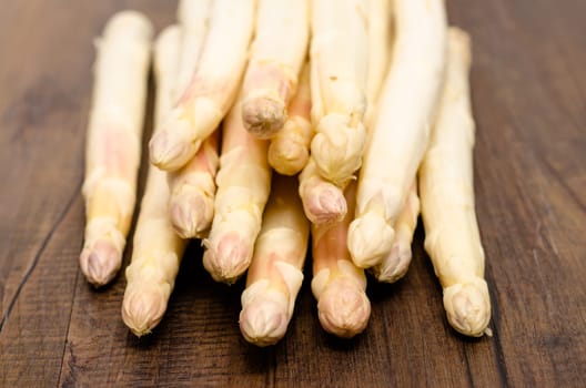 Sticks of white asparagus on brown wood