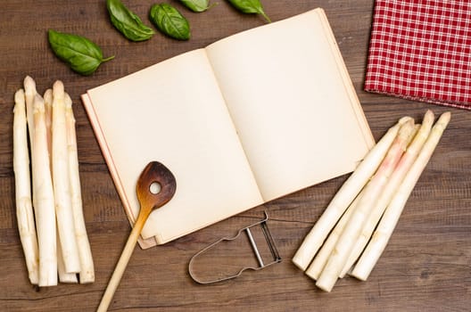 Book with text freedom,cooking spoon,asparagus,basil,napkin and peeler