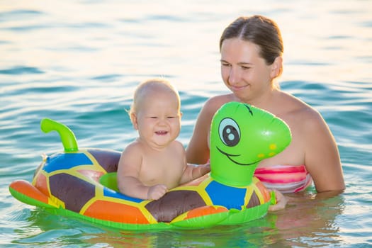 Baby and mother having fun time in the sea