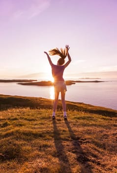 Young girl enjoying life in a beautiful sunset