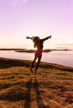 Young girl jumping in a beautiful sunset