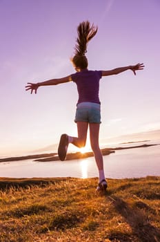 Young girl enjoying life in a beautiful sunset