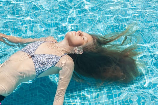Teenager relaxing in a pool in the summertime