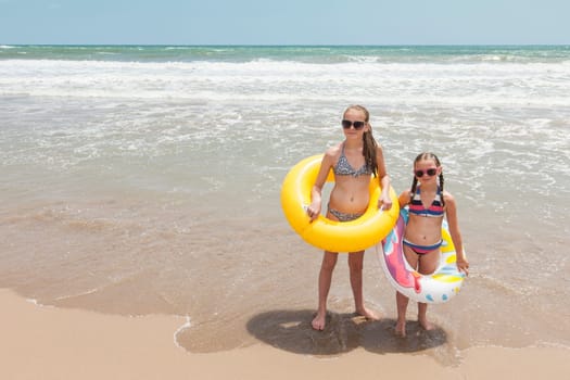 Two girls having fun on a beautiful beach in the summertime
