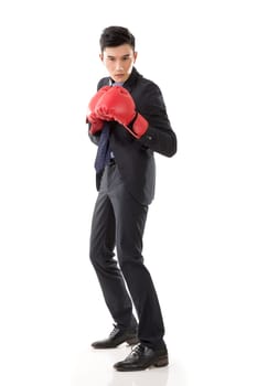 Asian businessman with boxing gloves, full length portrait isolated on white background. Concept about fight, struggle, against etc.