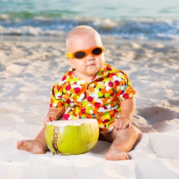 Funny baby wearing sunglasses with coconut