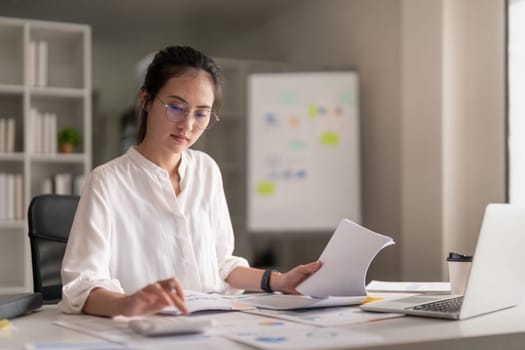 Businesswoman accountant using calculator and laptop for financial data saving in office room, Business financial, tax, accounting concept.