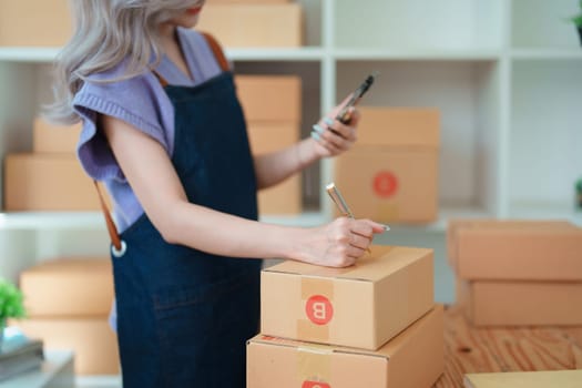 Asian female business owner handles delivery of orders to customers.