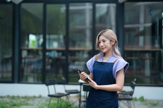 Startup successful small business owner sme beauty girl stand with tablet in coffee shop restaurant, asian tan woman barista cafe owner, entrepreneur seller business concept.