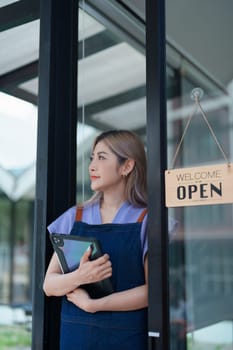 Startup successful small business owner sme beauty girl stand with tablet in coffee shop restaurant, asian tan woman barista cafe owner, entrepreneur seller business concept.