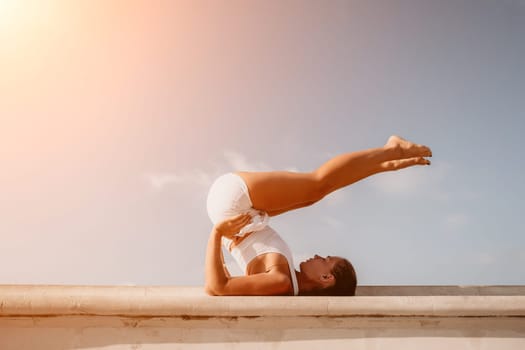 Fitness woman sea. Outdoor workout on yoga mat in park near to ocean beach. Female fitness pilates yoga routine concept. Healthy lifestyle. Happy fit woman exercising with rubber band in park.