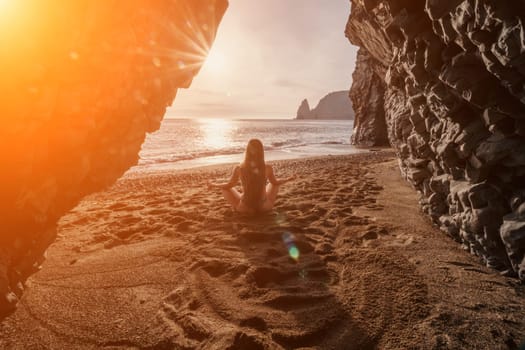 Middle aged well looking woman with black hair doing Pilates with the ring on the yoga mat near the sea on the pebble beach. Female fitness yoga concept. Healthy lifestyle, harmony and meditation.