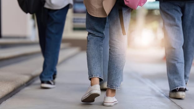 university students using a digital tablet while walking to next class.