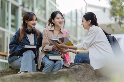 Group of Asian college student reading books and tutoring special class for exam at outdoors.