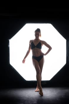 Silhouette of beautiful young woman wearing underwear in backlight