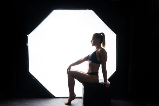 Silhouette of beautiful young woman wearing underwear in backlight