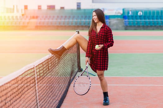 Beautiful stylish sexy woman in a black trendy sportswear on tennis court.