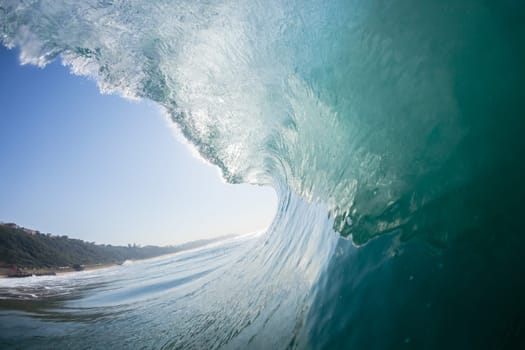 Ocean sea wave vertical crashing hollow tubing water power on shallow beach reefs sandbars, a swimming surfer action water photo