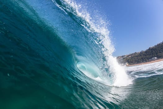 Ocean sea wave vertical crashing hollow tubing water power on shallow beach reefs sandbars, a swimming surfer action water photo