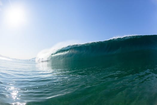 Ocean sea wave vertical crashing hollow tubing water power on shallow beach reefs sandbars, a swimming surfer action water photo