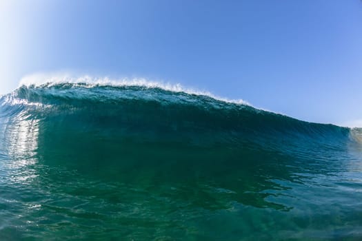 Ocean sea wave vertical crashing hollow tubing water power on shallow beach reefs sandbars, a swimming surfer action water photo