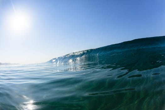 Ocean sea wave vertical crashing hollow tubing water power on shallow beach reefs sandbars, a swimming surfer action water photo