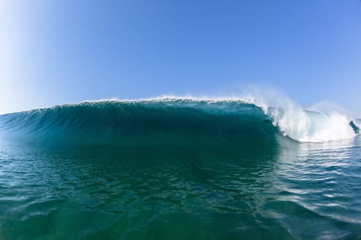 Ocean sea wave vertical crashing hollow tubing water power on shallow beach reefs sandbars, a swimming surfer action water photo