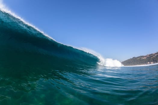 Ocean sea wave vertical crashing hollow tubing water power on shallow beach reefs sandbars, a swimming surfer action water photo