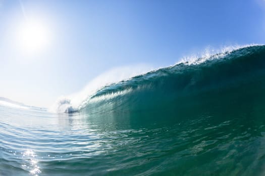 Ocean sea wave vertical crashing hollow tubing water power on shallow beach reefs sandbars, a swimming surfer action water photo