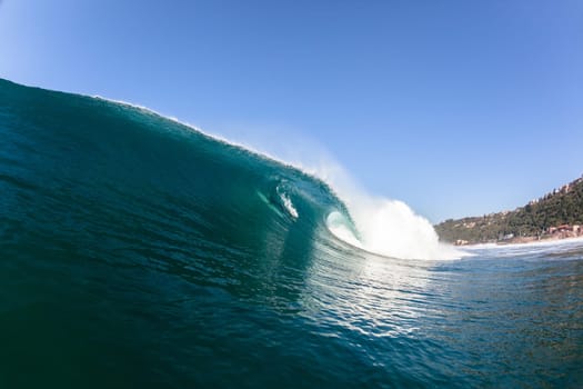Ocean sea wave vertical crashing hollow tubing water power on shallow beach reefs sandbars, a swimming surfer action water photo