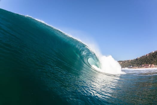 Ocean sea wave vertical crashing hollow tubing water power on shallow beach reefs sandbars, a swimming surfer action water photo