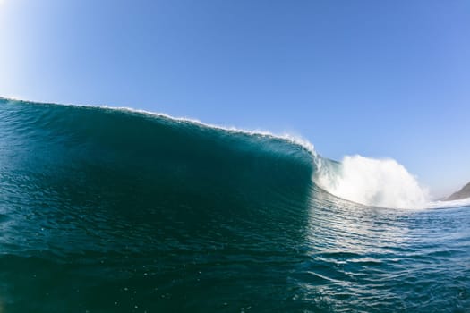 Ocean sea wave vertical crashing hollow tubing water power on shallow beach reefs sandbars, a swimming surfer action water photo
