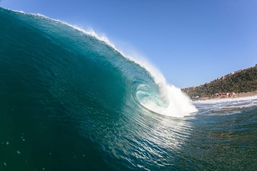 Ocean sea wave vertical crashing hollow tubing water power on shallow beach reefs sandbars, a swimming surfer action water photo