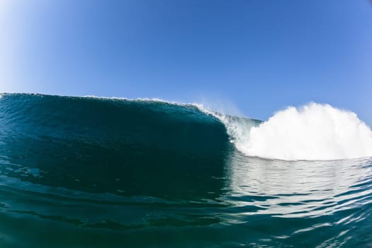 Ocean sea wave vertical crashing hollow tubing water power on shallow beach reefs sandbars, a swimming surfer action water photo