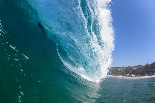 Ocean sea wave vertical crashing hollow tubing water power on shallow beach reefs sandbars, a swimming surfer action water photo