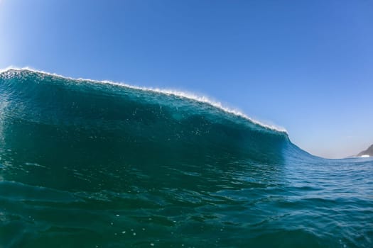 Ocean sea wave vertical crashing hollow tubing water power on shallow beach reefs sandbars, a swimming surfer action water photo