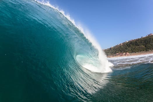 Ocean sea wave vertical crashing hollow tubing water power on shallow beach reefs sandbars, a swimming surfer action water photo