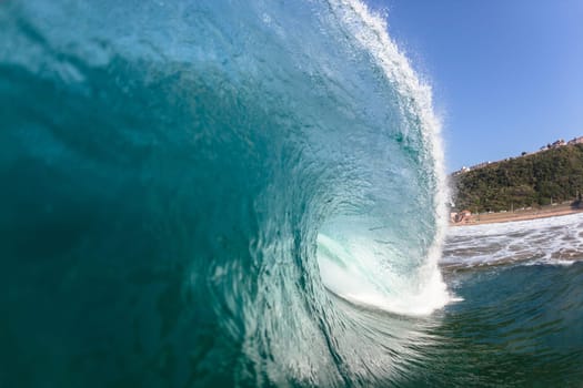 Ocean sea wave vertical crashing hollow tubing water power on shallow beach reefs sandbars, a swimming surfer action water photo