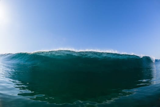Ocean sea wave vertical crashing hollow tubing water power on shallow beach reefs sandbars, a swimming surfer action water photo