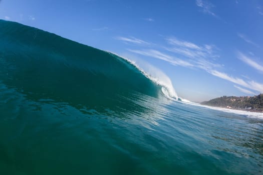 Ocean sea wave vertical crashing hollow tubing water power on shallow beach reefs sandbars, a swimming surfer action water photo