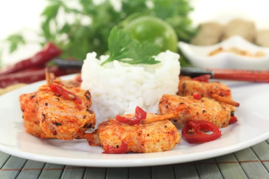 Meat skewer with pepperoni on a white plate
