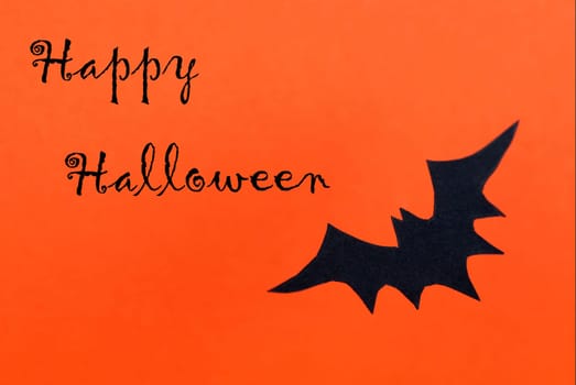 Happy Halloween written on an orange Background with a black Bat