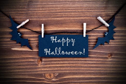Happy Halloween written on a Tag on a Wooden Background