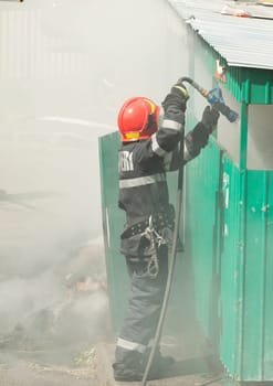 Firefighter in action - Fireman extinguishing a fire